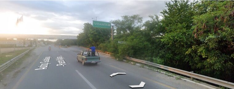 Satellite view of the VidantaWorld BON Park highway exit on MEX 200 immediately after the Ameca River bridge in Nuevo Nayarit, showing the green Vidanta overhead sign for LUDŌ show arrivals
